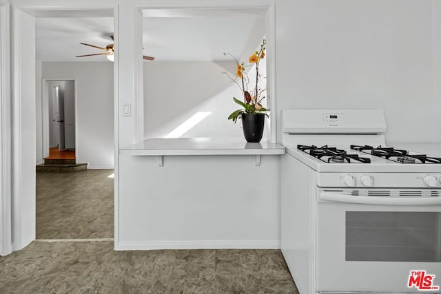 kitchen with white gas range and ceiling fan