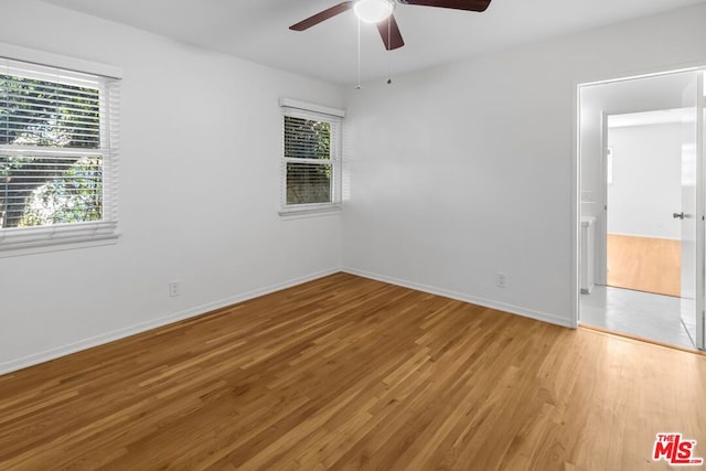 unfurnished room with ceiling fan, plenty of natural light, and light wood-type flooring