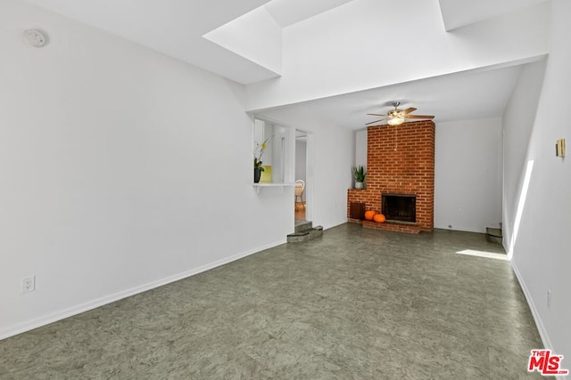 unfurnished living room featuring ceiling fan and a brick fireplace