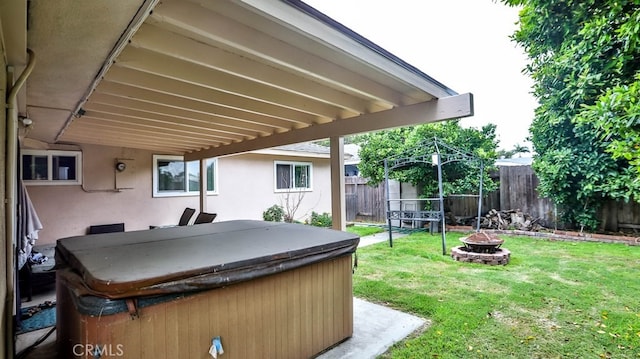 view of patio / terrace featuring a hot tub and an outdoor fire pit