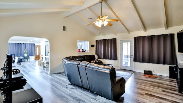 living room featuring beamed ceiling, a wealth of natural light, and hardwood / wood-style floors