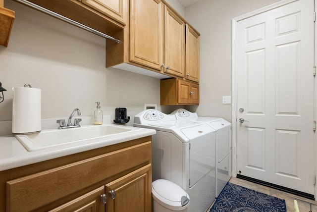 laundry room with cabinets, sink, washer and clothes dryer, and light tile patterned flooring