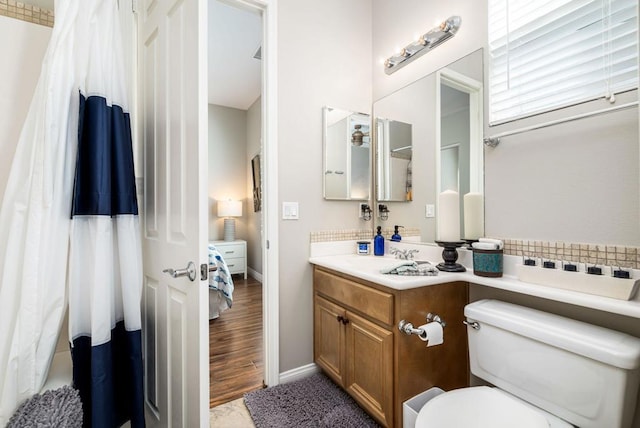 bathroom featuring toilet, hardwood / wood-style floors, and vanity