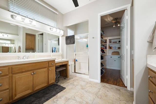 bathroom with vanity, ceiling fan, and a shower with door