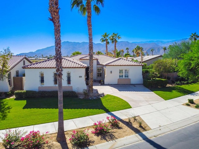 mediterranean / spanish-style home with a front yard and a mountain view