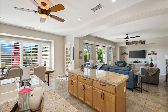 kitchen with ceiling fan, sink, and a kitchen island