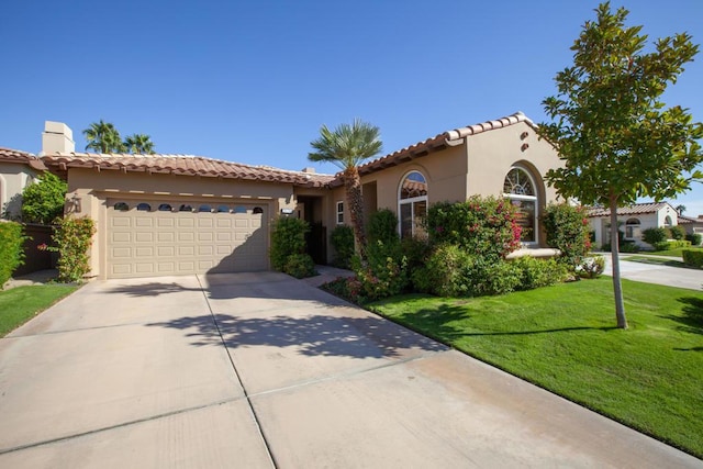 mediterranean / spanish house with a front lawn and a garage