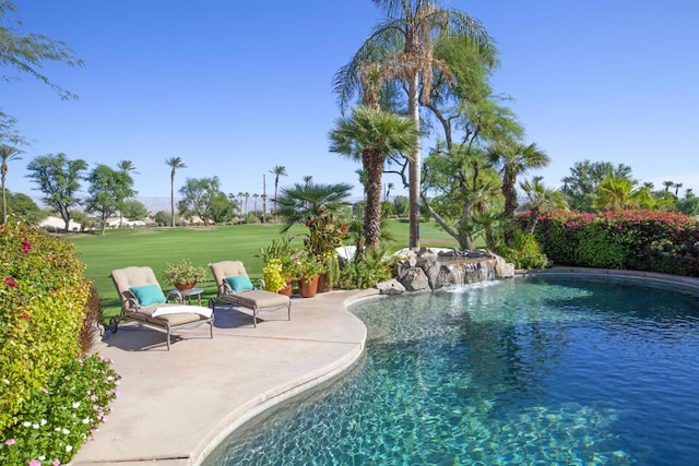 view of swimming pool featuring pool water feature, a patio area, and a lawn