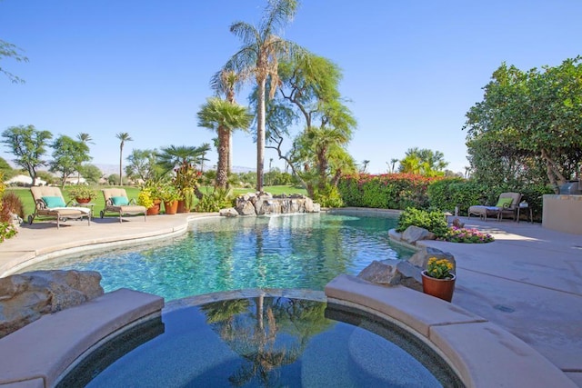 view of pool with a patio area and an in ground hot tub