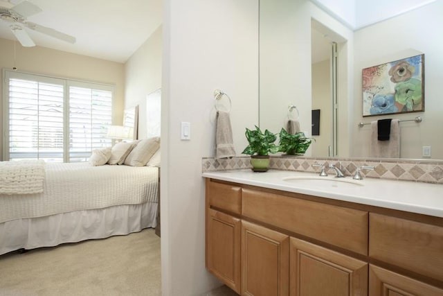 bedroom with ceiling fan, sink, and light carpet