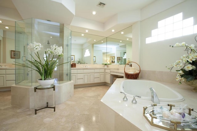 bathroom featuring vanity and tiled tub