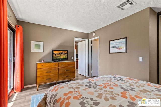 bedroom featuring hardwood / wood-style floors and a textured ceiling