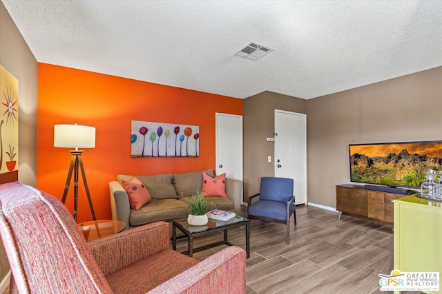 living room with wood-type flooring and a textured ceiling