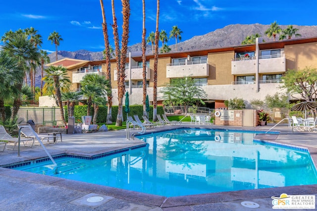 view of pool with a mountain view and a patio