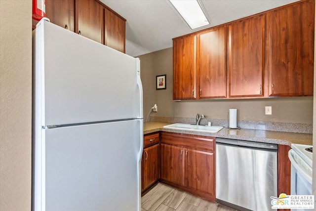 kitchen featuring white appliances, sink, and light hardwood / wood-style flooring