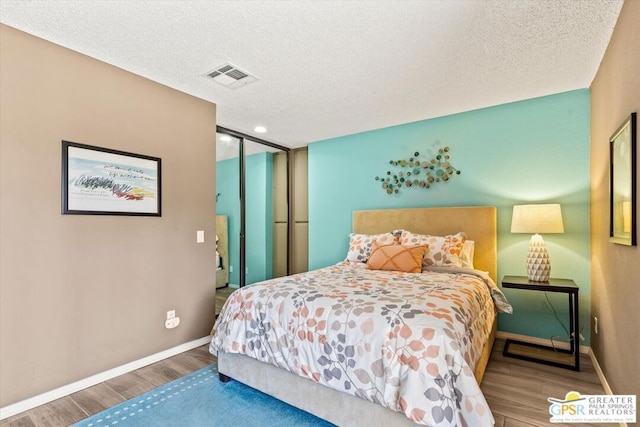 bedroom featuring hardwood / wood-style flooring and a textured ceiling