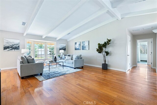 living room featuring hardwood / wood-style floors and lofted ceiling with beams