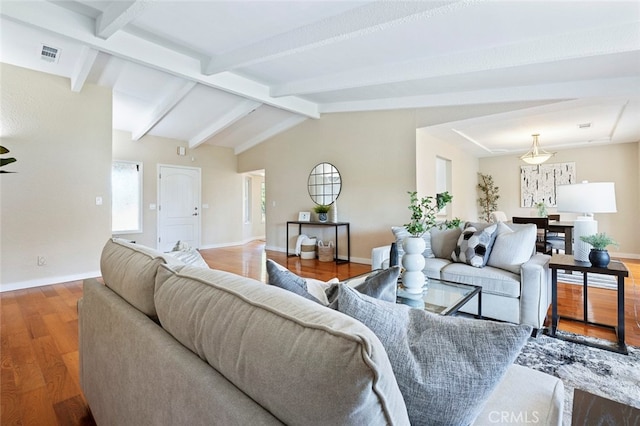 living room with vaulted ceiling with beams and hardwood / wood-style flooring