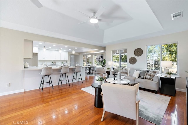 living room with ceiling fan and light hardwood / wood-style flooring