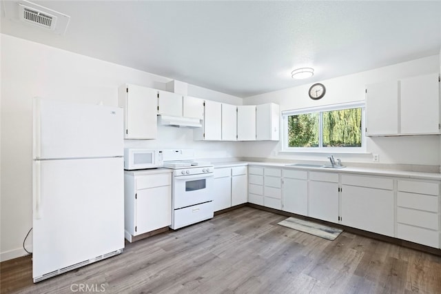 kitchen with white appliances, light hardwood / wood-style floors, sink, and white cabinets