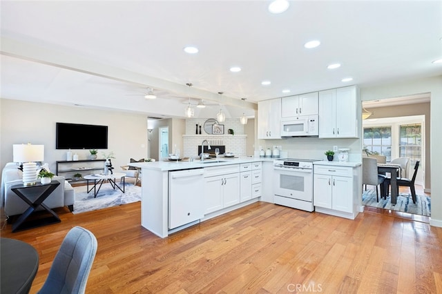 kitchen featuring white cabinets, light wood-type flooring, and white appliances