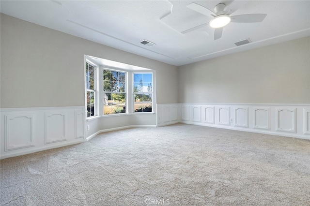 unfurnished room with light colored carpet and ceiling fan