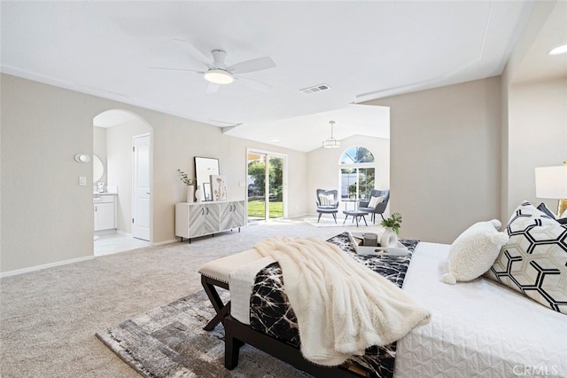 bedroom featuring vaulted ceiling, light carpet, ensuite bathroom, and ceiling fan