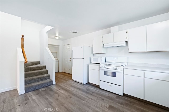 kitchen featuring washer / clothes dryer, white cabinetry, hardwood / wood-style floors, and white appliances