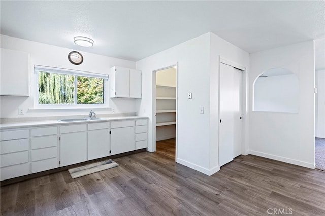 kitchen with dark wood-type flooring, sink, and white cabinets