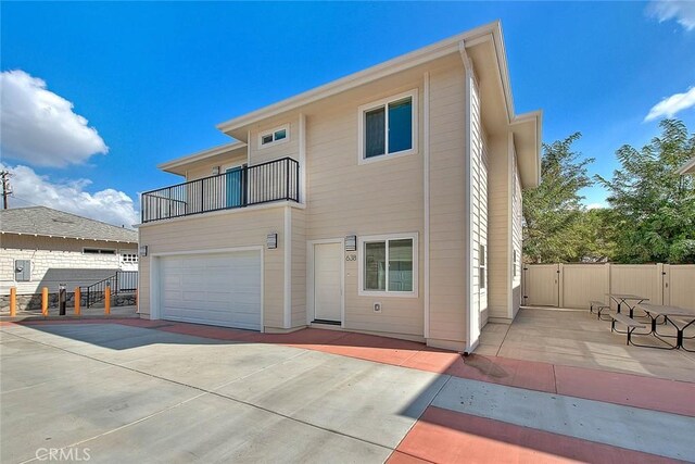 back of house with a garage and a balcony