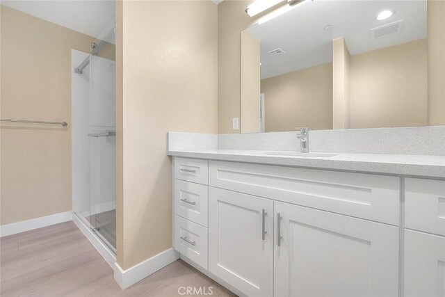 bathroom with vanity, hardwood / wood-style floors, and walk in shower