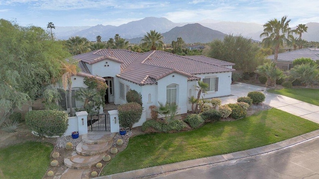 mediterranean / spanish house with a front yard and a mountain view