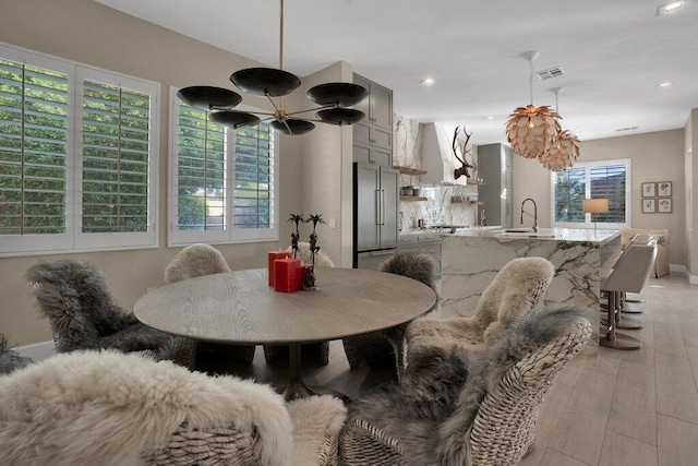 dining space featuring sink and light wood-type flooring