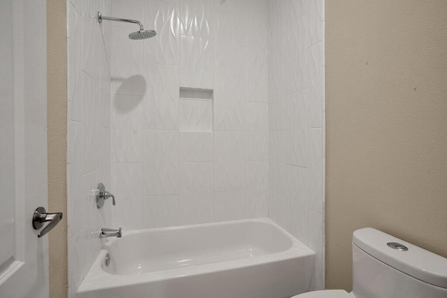 bathroom featuring tiled shower / bath and toilet