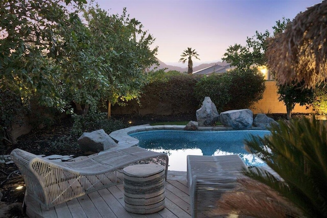 pool at dusk with a deck