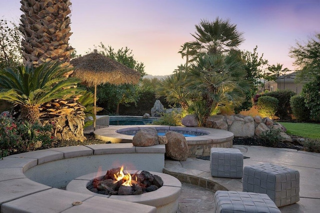 patio terrace at dusk featuring a fire pit