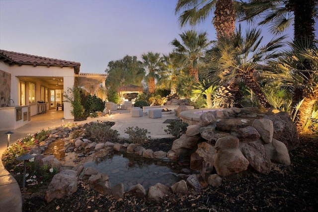 yard at dusk featuring sink and a patio area