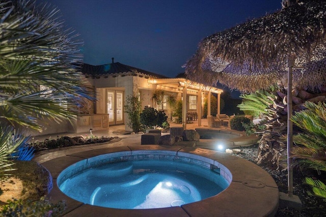 pool at twilight featuring french doors, a patio, and an in ground hot tub