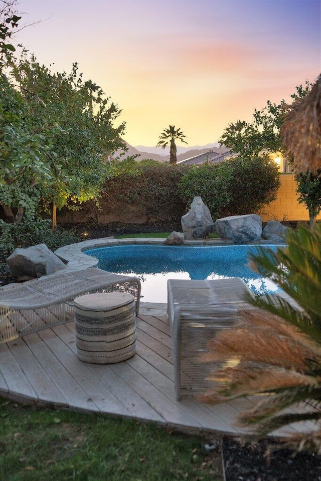 pool at dusk with a wooden deck