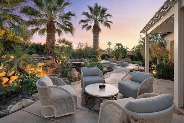 patio terrace at dusk featuring an outdoor living space and a pergola