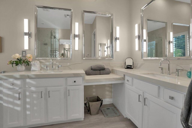 bathroom with hardwood / wood-style flooring, vanity, and an enclosed shower