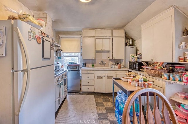 kitchen featuring gas water heater, vaulted ceiling, stainless steel range, white fridge, and sink