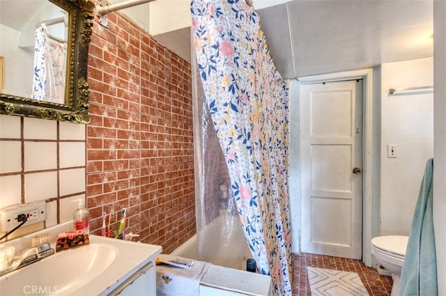 full bathroom featuring vanity, toilet, brick wall, and shower / tub combo