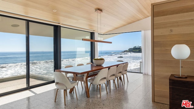 dining space featuring a water view, vaulted ceiling, a wealth of natural light, and wood ceiling