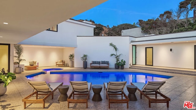 view of swimming pool featuring a patio area and an in ground hot tub