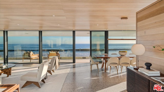 dining room featuring a water view, a wall of windows, and wood ceiling