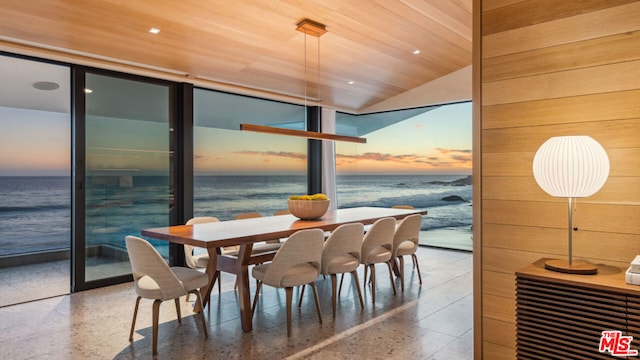 dining area with a water view, wood ceiling, and vaulted ceiling