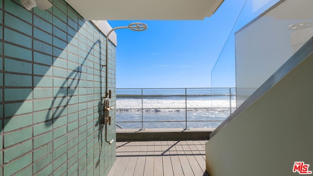 balcony featuring a view of the beach and a water view