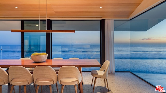 dining space with a water view and wooden ceiling