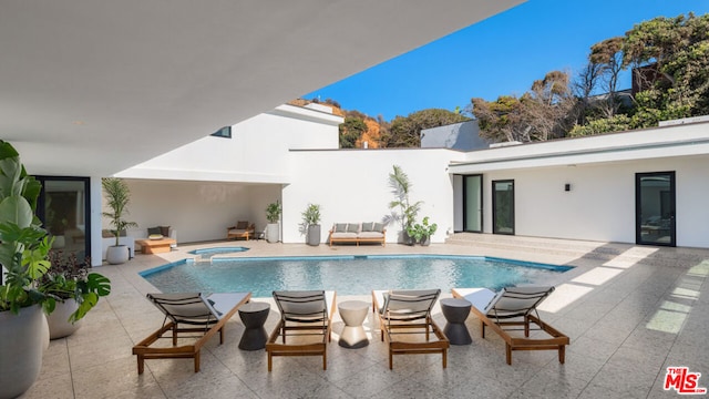 view of pool featuring a patio area and an in ground hot tub